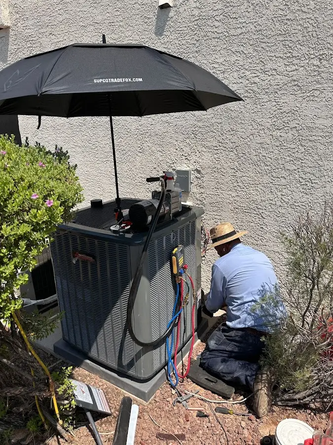 HVAC technician performing outdoor AC maintenance in Randolph